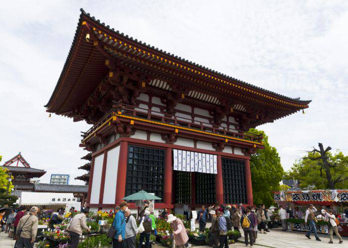 People wandering around at a traditional Japanese shrine and temple.