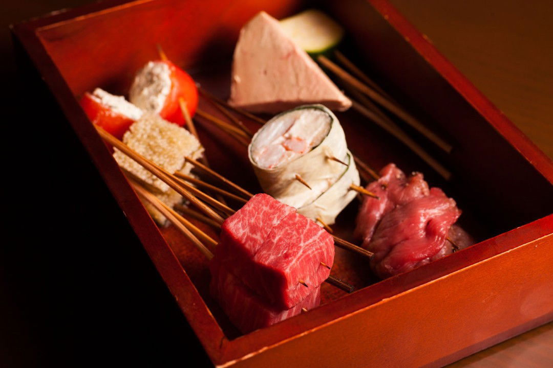 Gourmet skewers in a wooden box for a tasting menu course