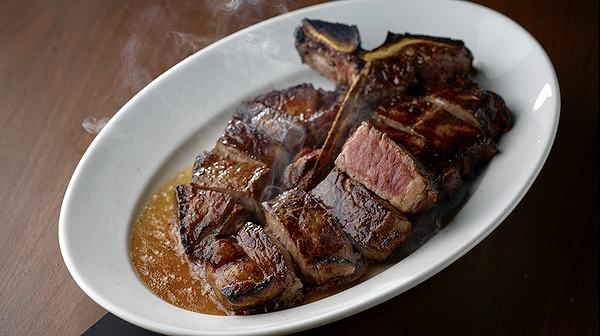 Juicy steak served on a white platter at a fine dining restaurant.