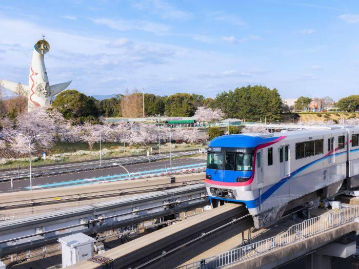 The monorail of the Expo ’70 Commemorative Park gliding past sakura trees.