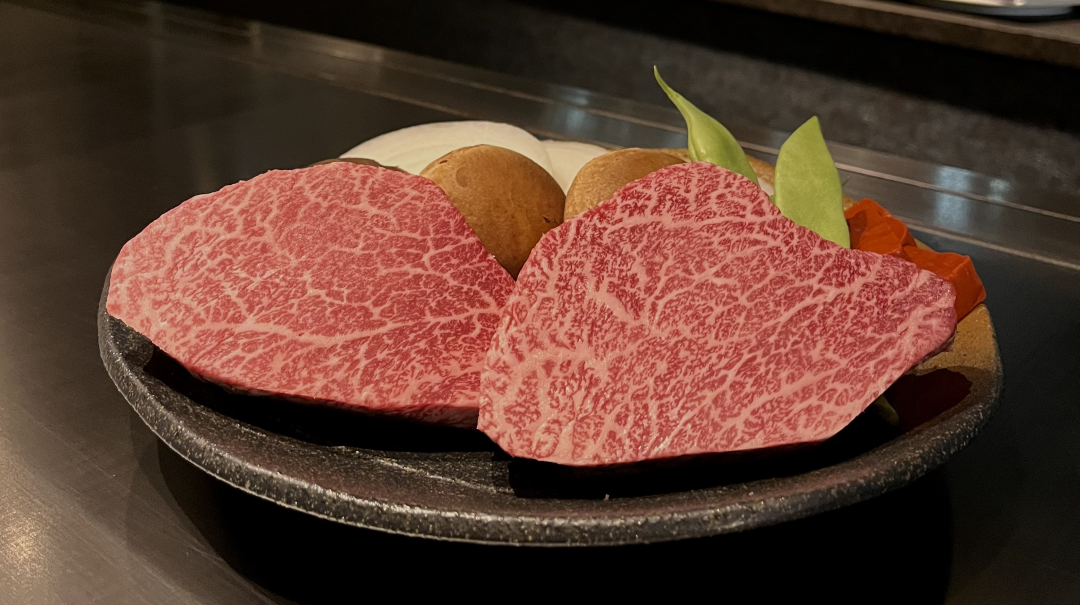Sliced wagyu beef with mushrooms and vegetables on a plate