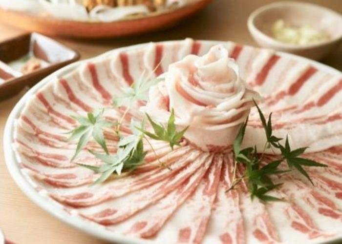 A plate of thinly sliced meat ready for shabu-shabu