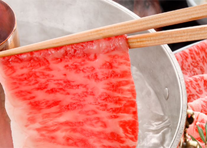 Beautifully marbled Japanese beef being dipped into soup at Imahan, a shabu shabu restaurant in Tokyo