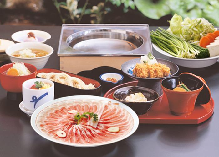 Shabu shabu layout at Ichiniisan, with meat, tofu, green veggies, and broth