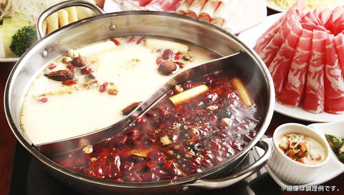 shabu shabu hot pot with two compartments, one with milky white broth and the other with chilis