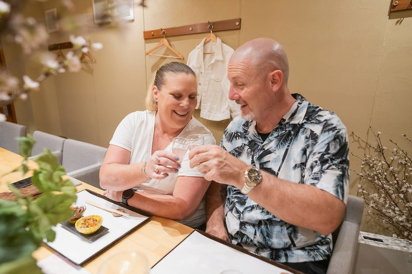 Couple enjoying a celebratory toast at a cozy restaurant setting