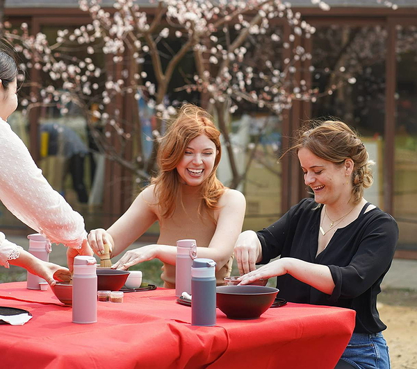 Friends enjoying a pottery class outdoors in a blooming garden
