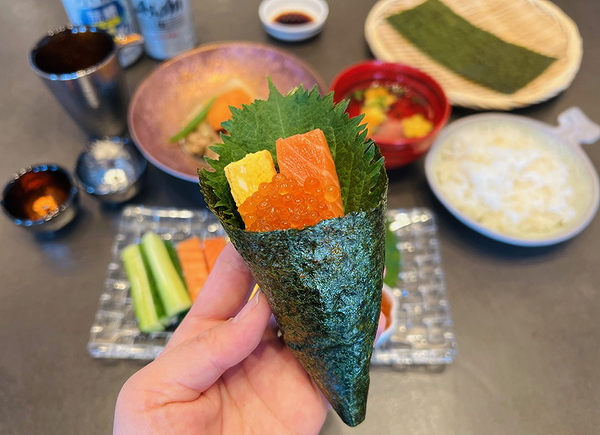 Hand-rolled sushi with salmon and roe on dining table