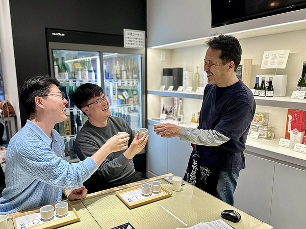 People enjoying sake tasting session in a cozy Japanese setting