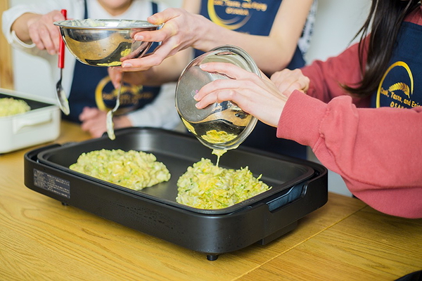Cooking class group making traditional Korean pancake