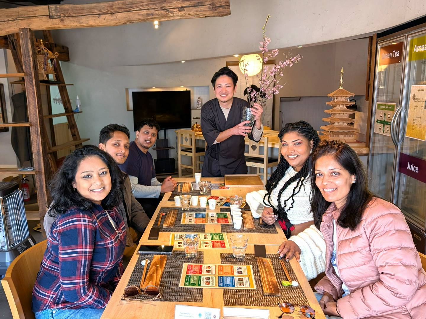 Group enjoying a guided tea tasting experience in a cozy Japanese tearoom