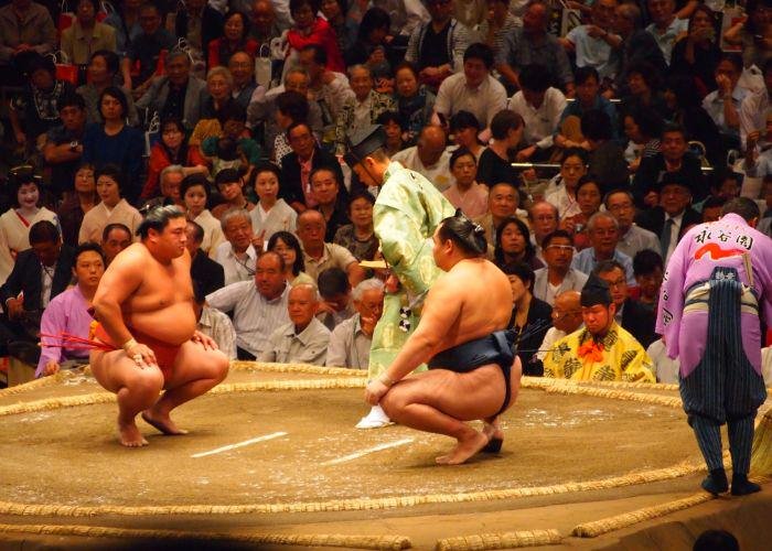 Two sumo wrestlers in a match area 