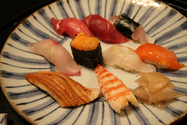 Assorted nigiri sushi on a decorative plate for a culinary experience.