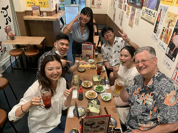 Group enjoying drinks and food in a cozy Japanese restaurant