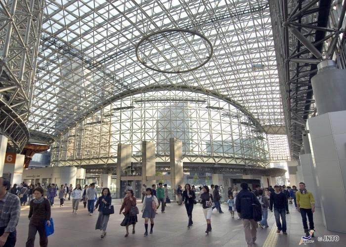 Modern-looking Kanazawa Station with a high glass ceiling with geometric beams