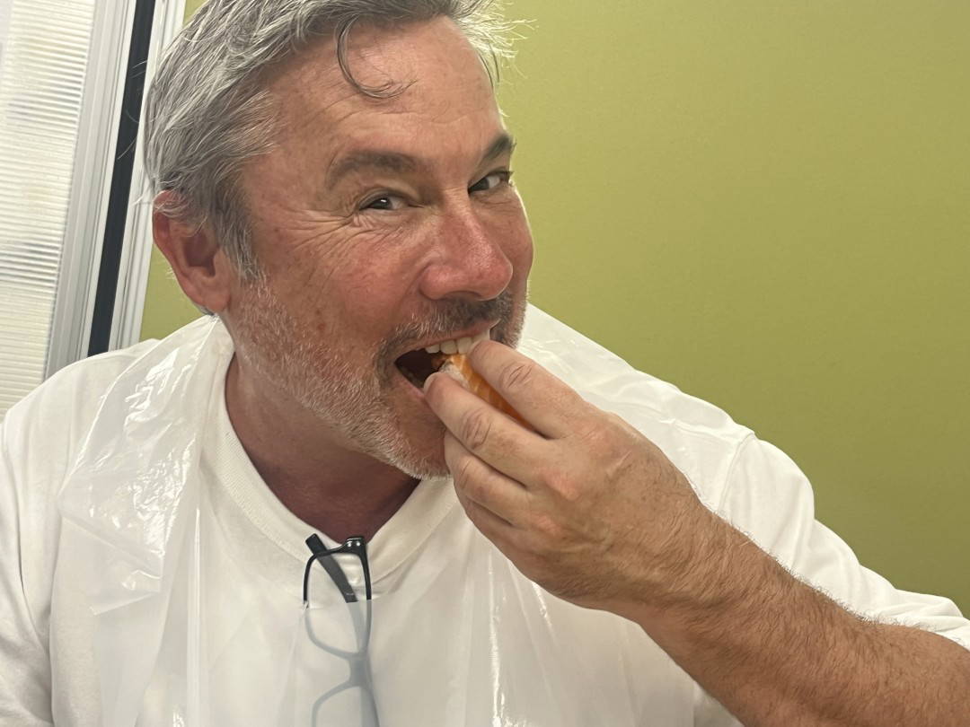 Smiling man enjoying a tasty snack indoors
