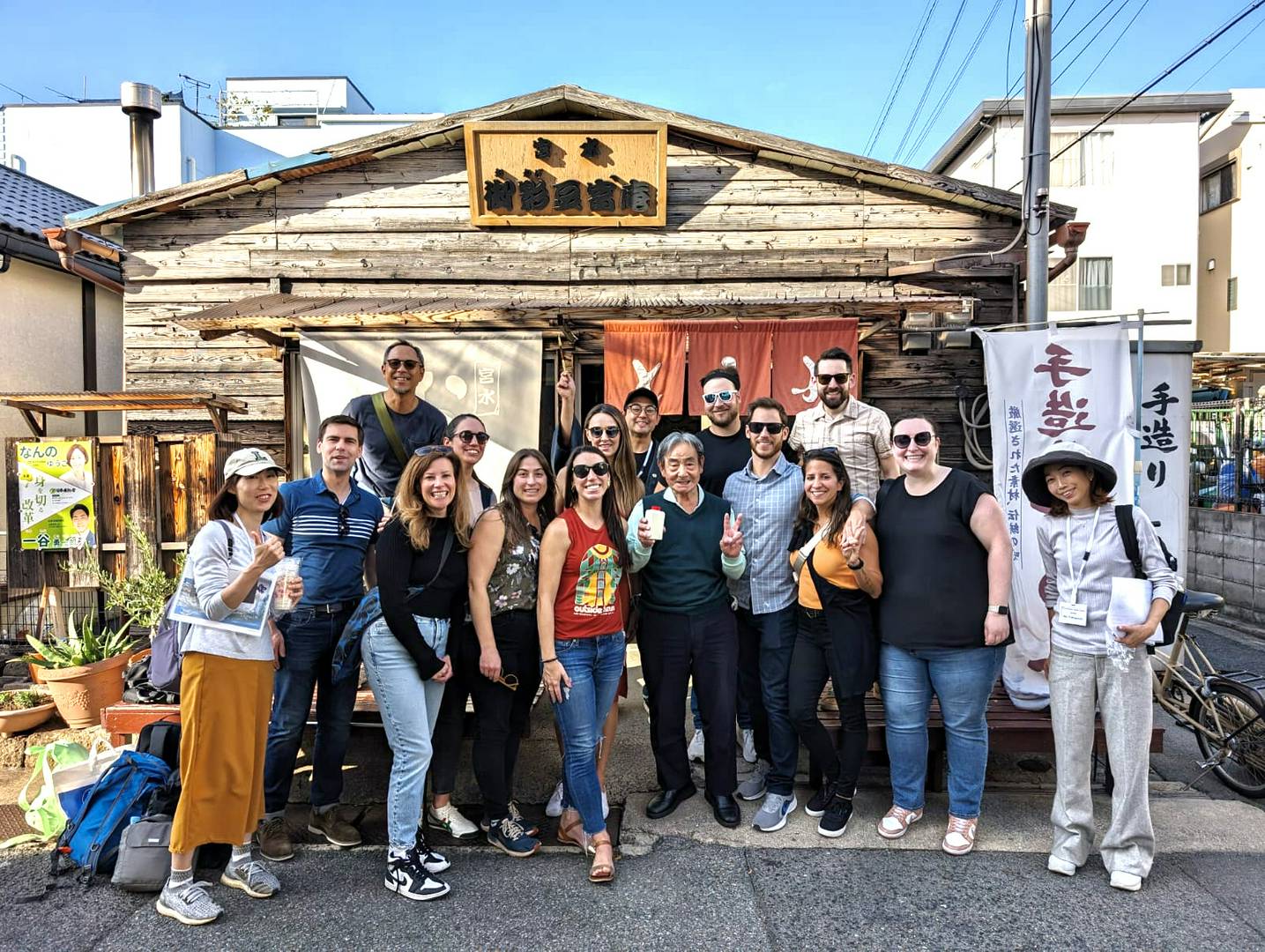 Group of tourists enjoying a cultural experience in front of a rustic building