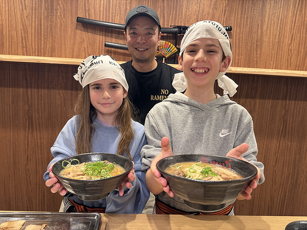 Two kids enjoying ramen cooking experience with chef
