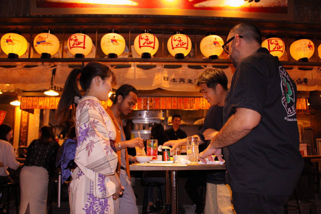 People enjoying Japanese street food with traditional lanterns