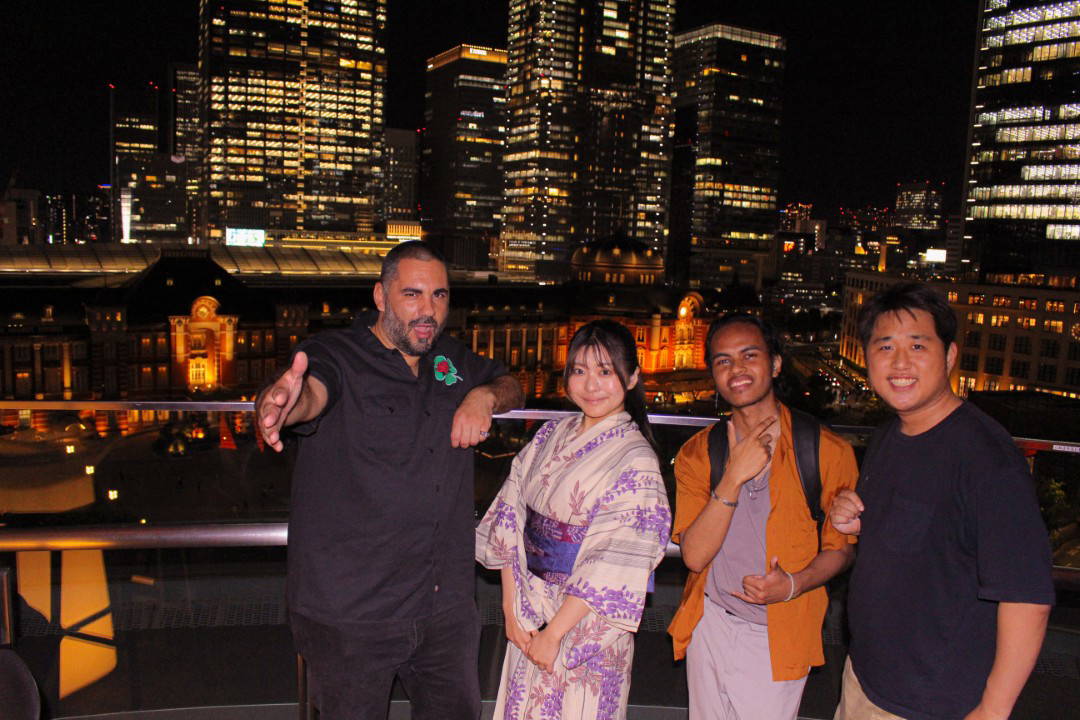 Group enjoying Tokyo skyline from rooftop at night
