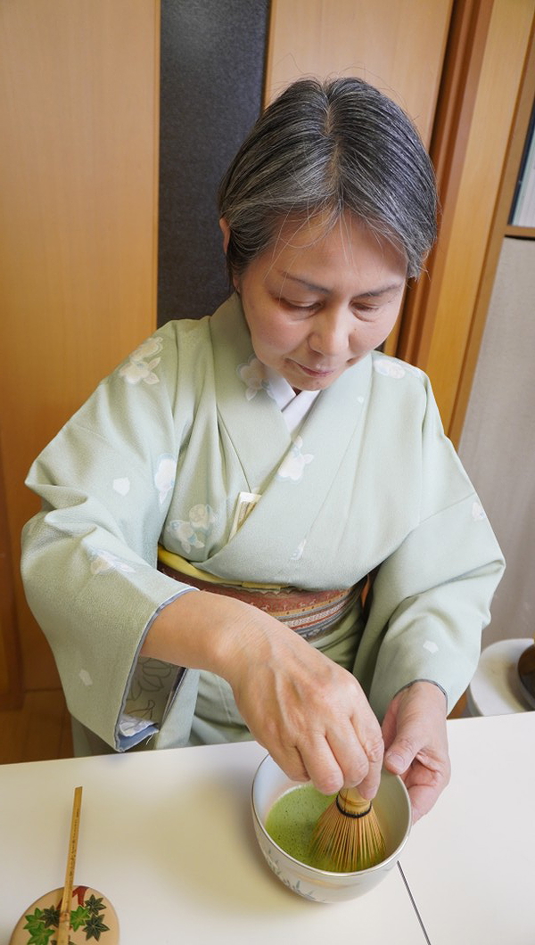 Woman preparing matcha in traditional Japanese tea ceremony