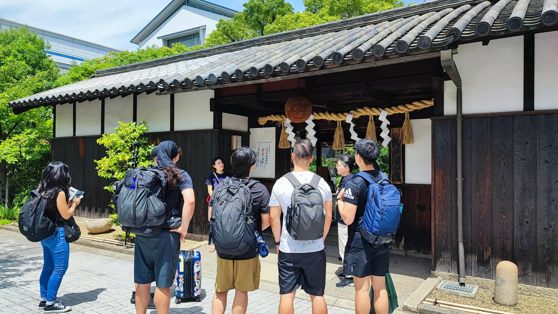 Travelers exploring traditional Japanese brewery entrance