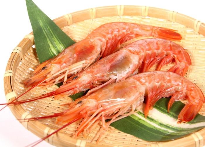 Pink cooked ebi prawns on a bamboo tray