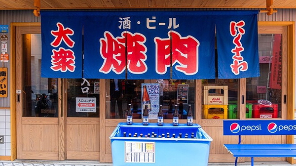 Japanese yakiniku restaurant entrance with traditional blue curtain
