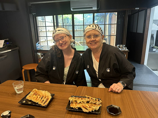 Mother and daughter enjoying freshly made gyoza in traditional Japanese attire.