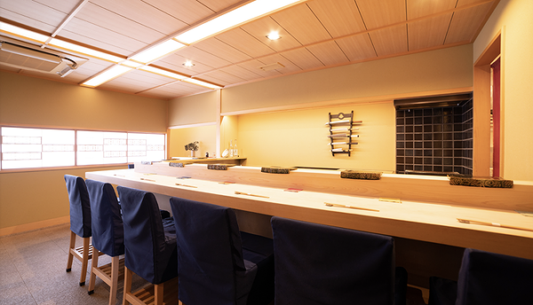 Elegant sushi bar interior with wooden decor and blue chairs