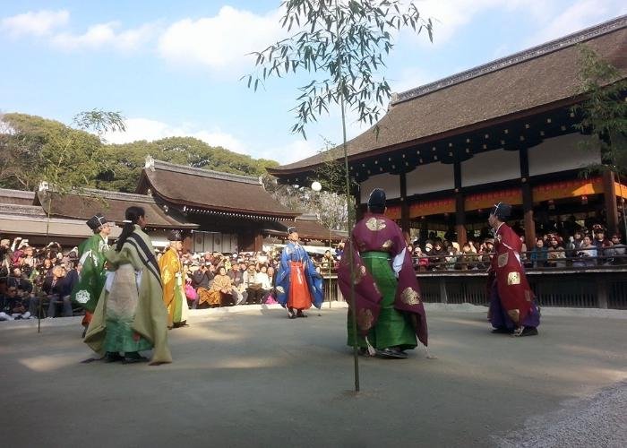 Players in colorful traditional clothing are kicking the “Mari” ball
