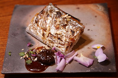 Gourmet grilled fish with floral garnishes on decorative plate