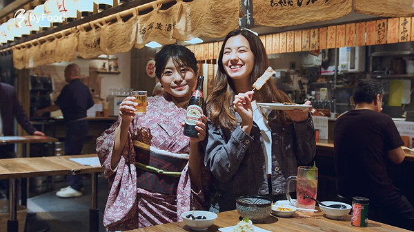 Two women enjoying drinks in a Japanese izakaya
