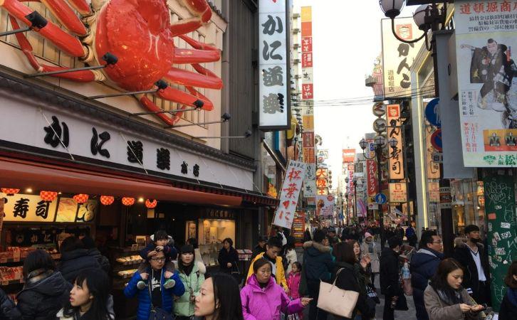 The crowded streets of Osaka, featuring a storefront with a big crab on.