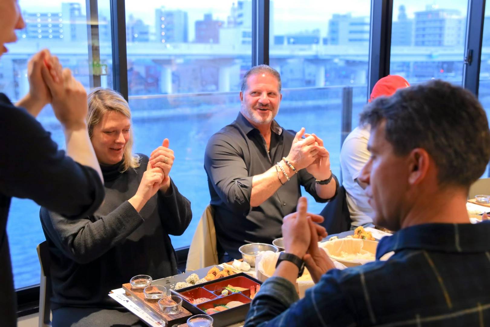 Group enjoying sushi-making class by a riverside view