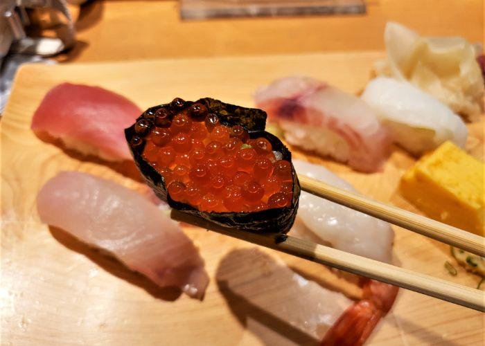 A close-up shot of the orange bubble salmon roe nigiri