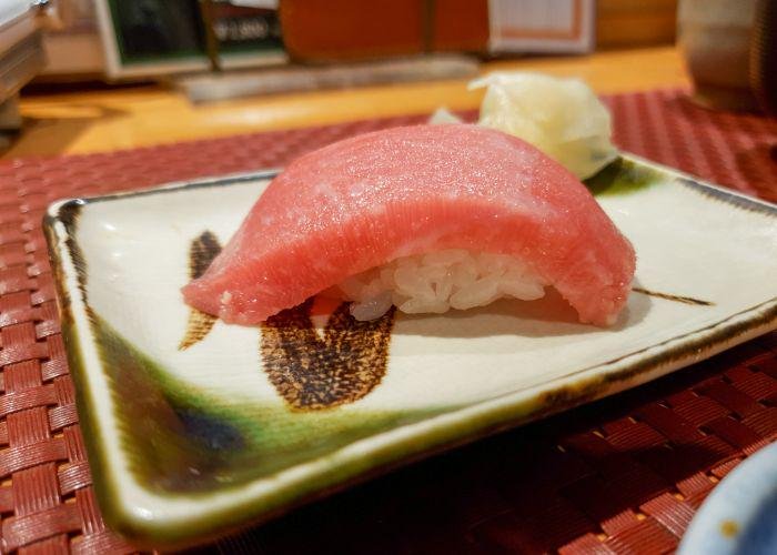 A side view of the otoro nigiri showing a thick slice with a small amount of rice underneath 