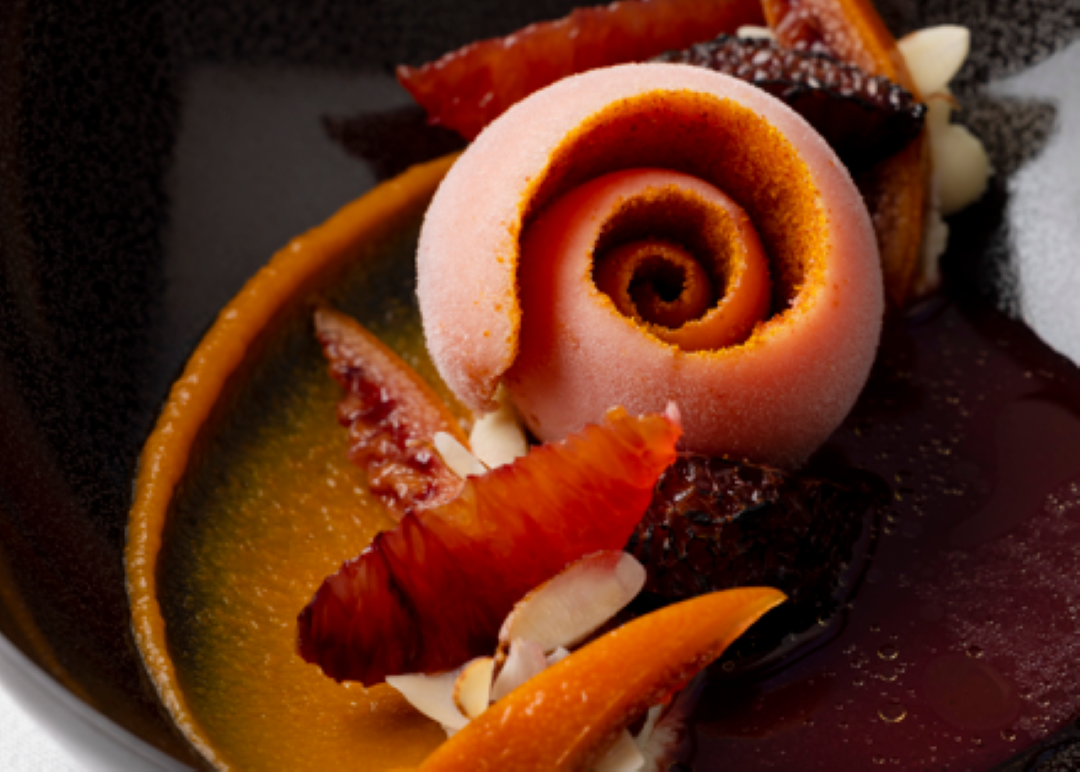 Elegant dessert presentation with blood orange and almond accents