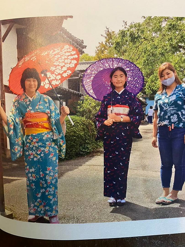 Women in traditional kimonos with parasols enjoy a sunny stroll