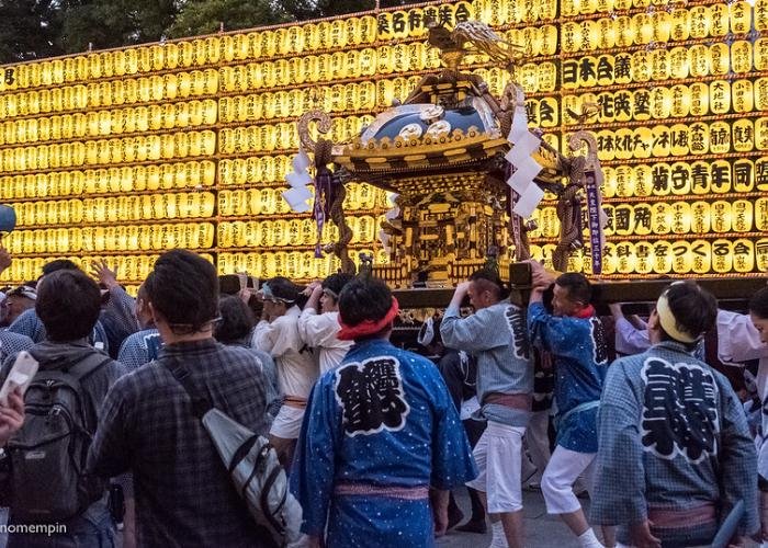 Mikoshi parade in front of thousands of golden lanterns.