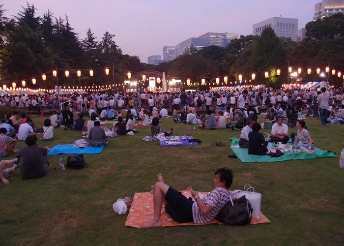 Visitors can picnic in the field of the park in front of stalls during the festival.
