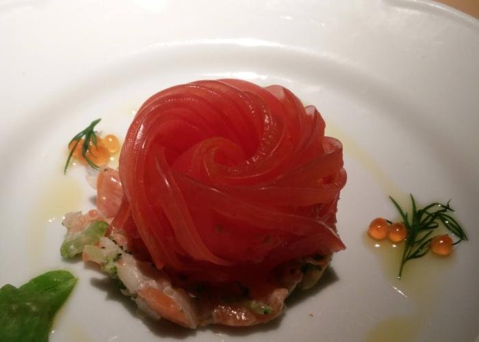 tomato rose laid over some delicious seafood, like roe eggs