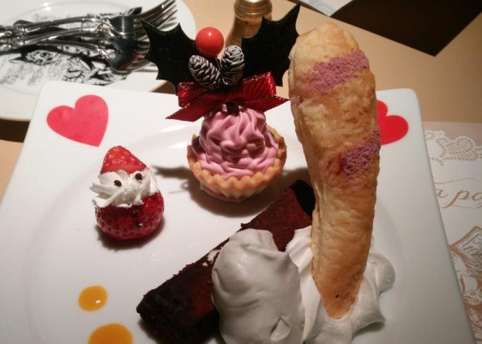 Christmas-themed dessert at Alice in a Labyrinth restaurant. Cheshire Cat’s tail and a sweet strawberry Santa, pink tart, with lots of cream