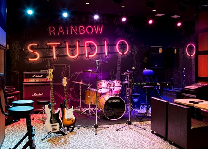 Studio room equipped with musical instruments like guitars and drums.