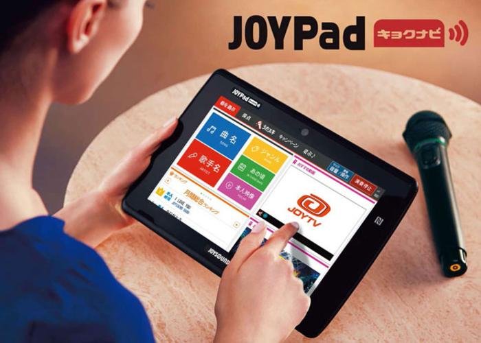 A lady is using Joysound tablet to choose songs.