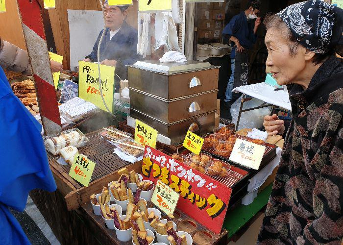 Old lady selling fried snacks at her stall