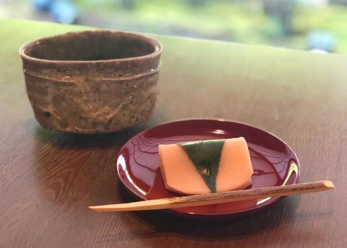 A beautiful sakura mochi, red bean paste wrapped in a smooth mochi exterior, enveloped in a sakura leaf