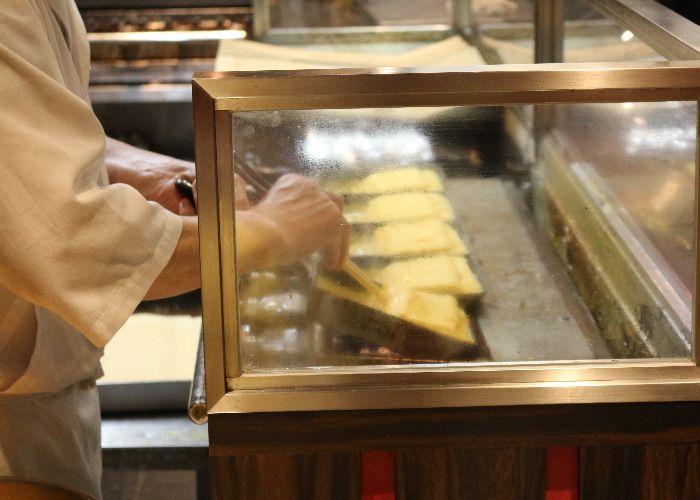 The tamagoyaki chef is turn the omelettes in the tamagoyaki pan