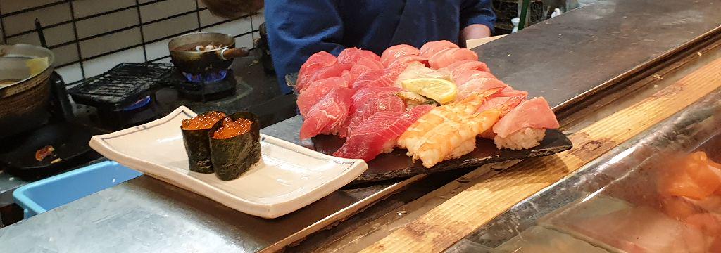 Assorted sushi platter with nigiri and sashimi on a restaurant counter