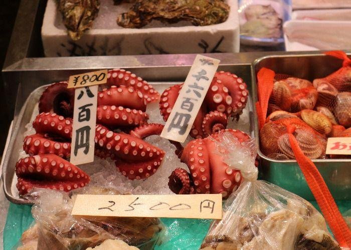 Bright red octopuses on ice for sale or sashimi
